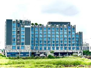 a large building with blue windows in a city at Sungsan Marina Hotel in Seogwipo