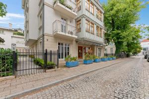 a building on a street with potted plants on the sidewalk at Luxury Willa Morska by Grand Apartments in Sopot