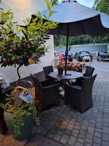 a table and chairs with an umbrella on a patio at Domek letniskowy 2 os Zacisze in Międzyzdroje