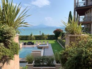a backyard with a swimming pool with a view of the ocean at Lake Garda Lovers Luxury in Peschiera del Garda