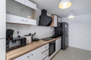 a kitchen with white cabinets and a wooden counter top at Dreaming Landscape Luciano - piscina y parking gratis in Cenes de la Vega