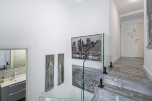 a bathroom with two pictures on the wall at Dreaming Landscape Luciano - piscina y parking gratis in Cenes de la Vega +28 photos