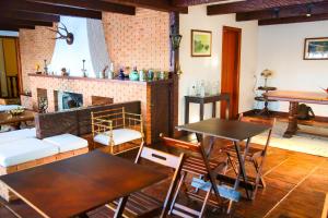 a living room with tables and a fireplace at Villa Iturri in Campos do Jordão
