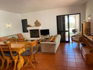 ein Wohnzimmer mit einem Holztisch und einem Esszimmer in der Unterkunft Beach House Golden Club in Cabanas de Tavira