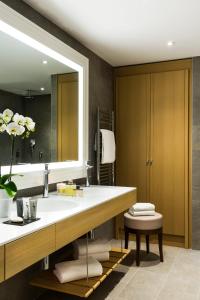 baño con lavabo y espejo grande en Hôtel Barrière L'Hôtel du Golf, en Deauville