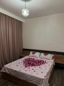 1 dormitorio con 1 cama cubierta de rosas en NBG tower, en Batumi