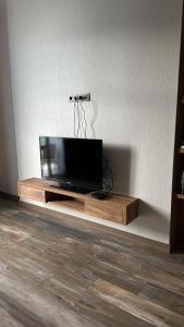 TV de pantalla plana sobre una mesa de madera en NBG tower, en Batumi 10 fotos más