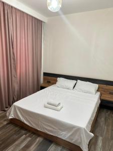 Un dormitorio con una cama con dos toallas blancas encima. en NBG tower, en Batumi