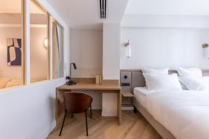 a bedroom with a bed and a desk and a bed and a bed at Quartier Libre Opera in Paris