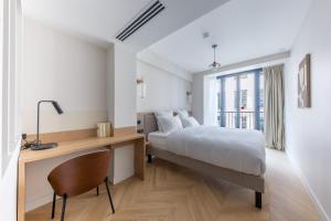 a bedroom with a bed and a desk with a chair at Quartier Libre Opera in Paris