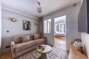a living room with a couch and a table at Quartier Libre Opera in Paris
