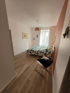 Un dormitorio con una cama y una silla en una habitación. en Logement centre le bugue, en Le Bugue