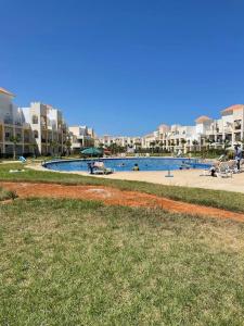 a large swimming pool in a city with buildings at Appartement au bord de la mer in Saidia 