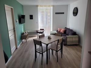 una sala de estar con una mesa y un sofá en Logement centre le bugue, en Le Bugue 14 fotos más