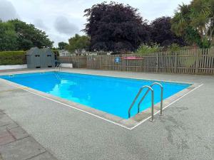a large blue swimming pool in a yard at Cornwall caravan in Crantock