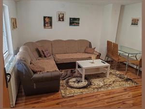 a living room with a couch and a table at Stan na dan BALANS in Ledine +3 photos