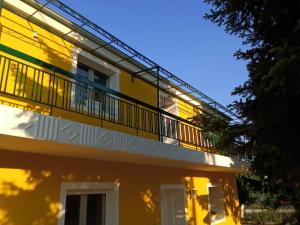 un edificio giallo con un balcone sopra di Yellow House a Eleftheroúpolis