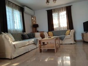 un soggiorno con due divani e un tavolino da caffè di Yellow House a Eleftheroúpolis