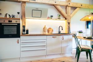 ジークスドルフにあるFerienwohnung Chiemgau Nestの白いキャビネット、シンク、テーブル付きのキッチンが備わります。