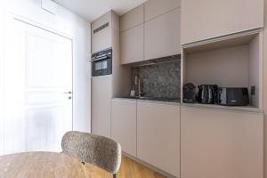 a kitchen with white cabinets and a table and a chair at Quartier Libre Opera in Paris