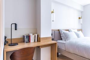 a bedroom with a desk next to a bed at Quartier Libre Opera in Paris