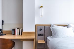 a bedroom with a bed and a wooden desk at Quartier Libre Opera in Paris
