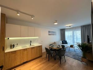 a kitchen and a living room with a table at Anchoria Holiday SPA in Mechelinki