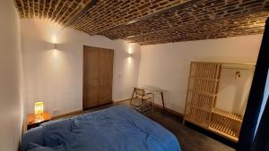 a bedroom with a blue bed and a wooden ceiling at Bed and breakfast Le fourchu fossé in Liège