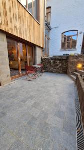 a patio with a table and chairs in front of a building at Bed and breakfast Le fourchu fossé in Liège