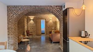 a kitchen with a brick archway and a living room at Bed and breakfast Le fourchu fossé in Liège