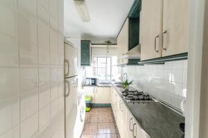 a kitchen with white cabinets and a stove top oven at LAS VEGAS CENTRO- HOME RENt MALAGA in Torre del Mar