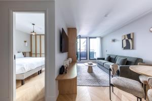 a bedroom and a living room with a couch and a bed at Quartier Libre Opera in Paris