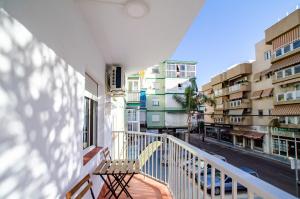 a balcony with a chair and some buildings at LAS VEGAS CENTRO- HOME RENt MALAGA in Torre del Mar