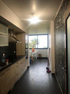 an empty kitchen with a large window and a table at Magic Paradisus guest in Caniço
