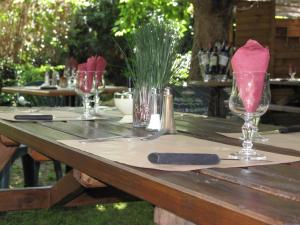 une table en bois avec des verres à vin et un couteau dans l'établissement Hôtel Le Juliano, à Carbon-Blanc