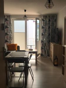 a dining room with a table and chairs and windows at Kosmos nad morzem in Dziwnówek