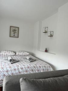 una camera da letto bianca con un letto e un divano di L'ethnique cottage 30m2 2 personnes avec extérieur a Villeneuve d'Ascq