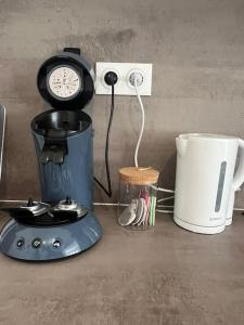 una macchinetta del caffè e un orologio su un bancone di L'ethnique cottage 30m2 2 personnes avec extérieur a Villeneuve d'Ascq