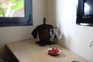 two wine glasses and a bowl of fruit on a table at Hotel Cal Tet in L'Estartit
