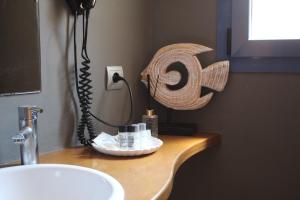 a bathroom counter with a sink and a lightswitch at Hotel Cal Tet in L'Estartit