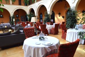 un restaurante con mesas y sillas blancas y buscador de mesa en Hacienda Montija Hotel en Huelva