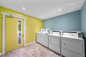 a laundry room with white washing machines and green walls at Shores Inn & Hotel in Shediac +61 photos
