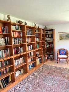 biblioteca con librerie in legno piene di libri di Ferienhaus Malterlehen a Marktschellenberg Altre 28 foto