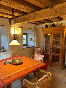 una sala da pranzo con tavolo arancione e sedie di Ferienhaus Malterlehen a Marktschellenberg