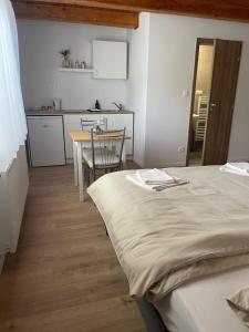 a bedroom with a bed and a table and a kitchen at Ubytovanie na Pánskej in Terchová