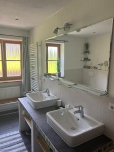 a bathroom with two sinks and a large mirror at Ferienhaus Malterlehen in Marktschellenberg +28 photos