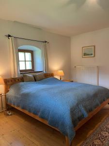a bedroom with a large bed with a blue comforter at Ferienhaus Malterlehen in Marktschellenberg