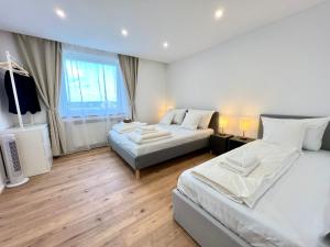 a hotel room with two beds and a television at GOLDVILLA - Wesseling SW in Wesseling