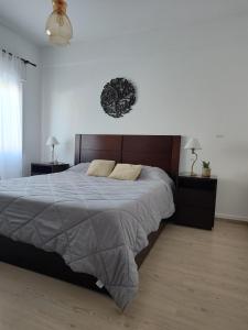 Un dormitorio con una cama grande con dos mesas y dos lámparas. en Depto Aqua 2, en Posadas