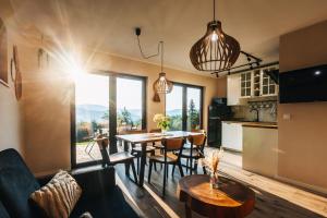 a kitchen and living room with a table and chairs at Zawoja House in Zawoja